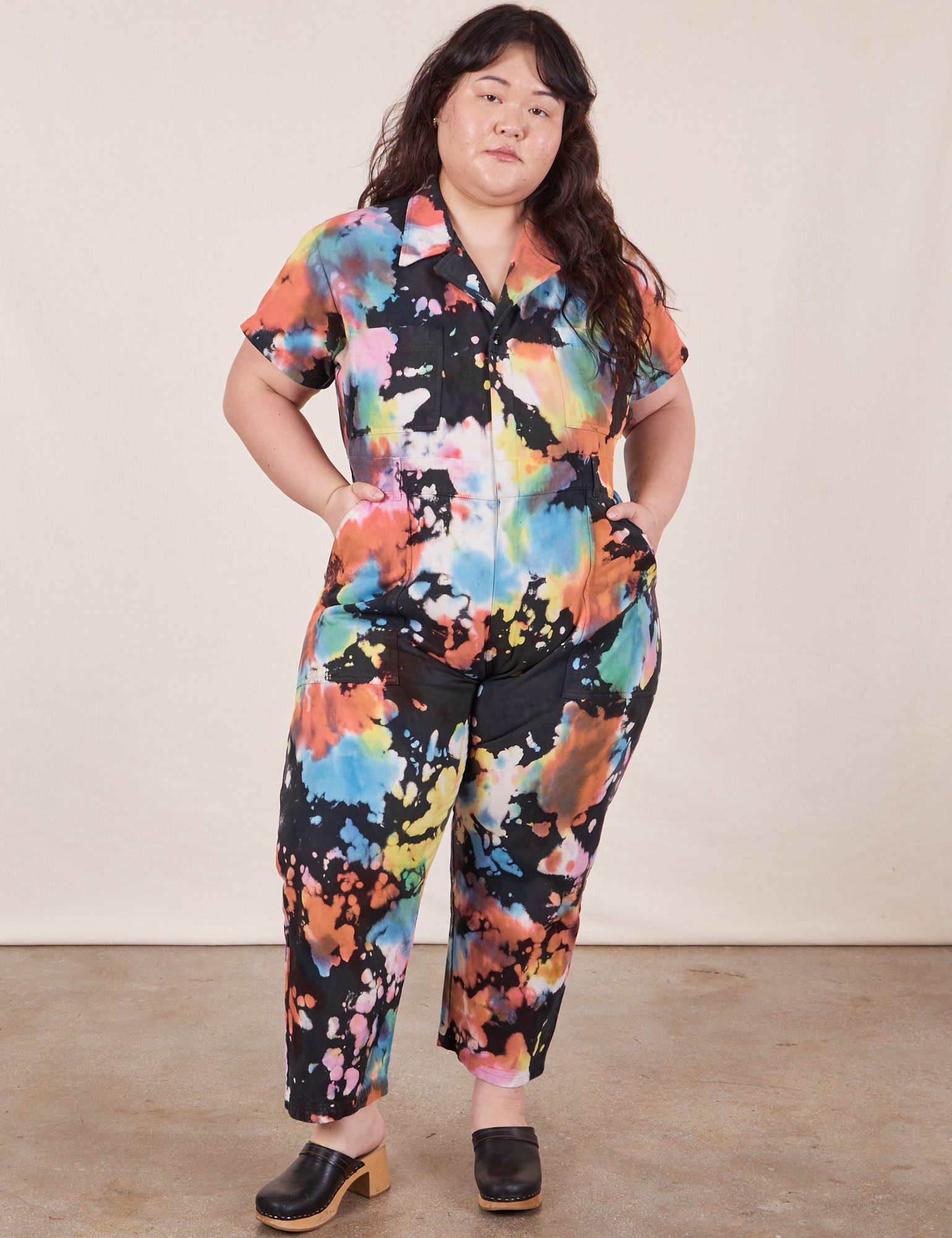 Ashley is 5'7" and wearing 1XL Petite Petite Short Sleeve Jumpsuit in Rainbow Magic Waters
