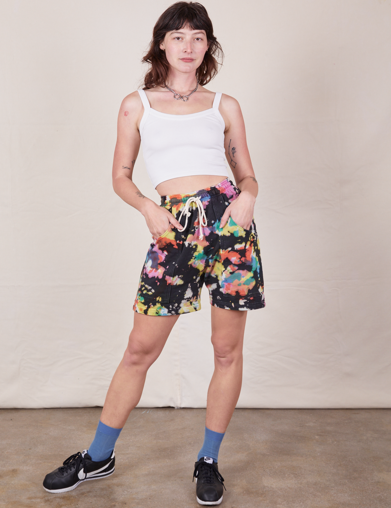 Alex is 5’8” and wearing XXS Sweat Shorts in Rainbow Magic Waters paired with vintage off-white Cami