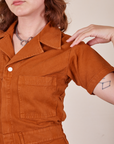 Front close up of Short Sleeve Jumpsuit in Burnt Terracotta worn by Alex