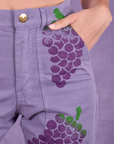 Close up of Madeline's hand in the front pocket of Paintstamped Work Pants in Grape