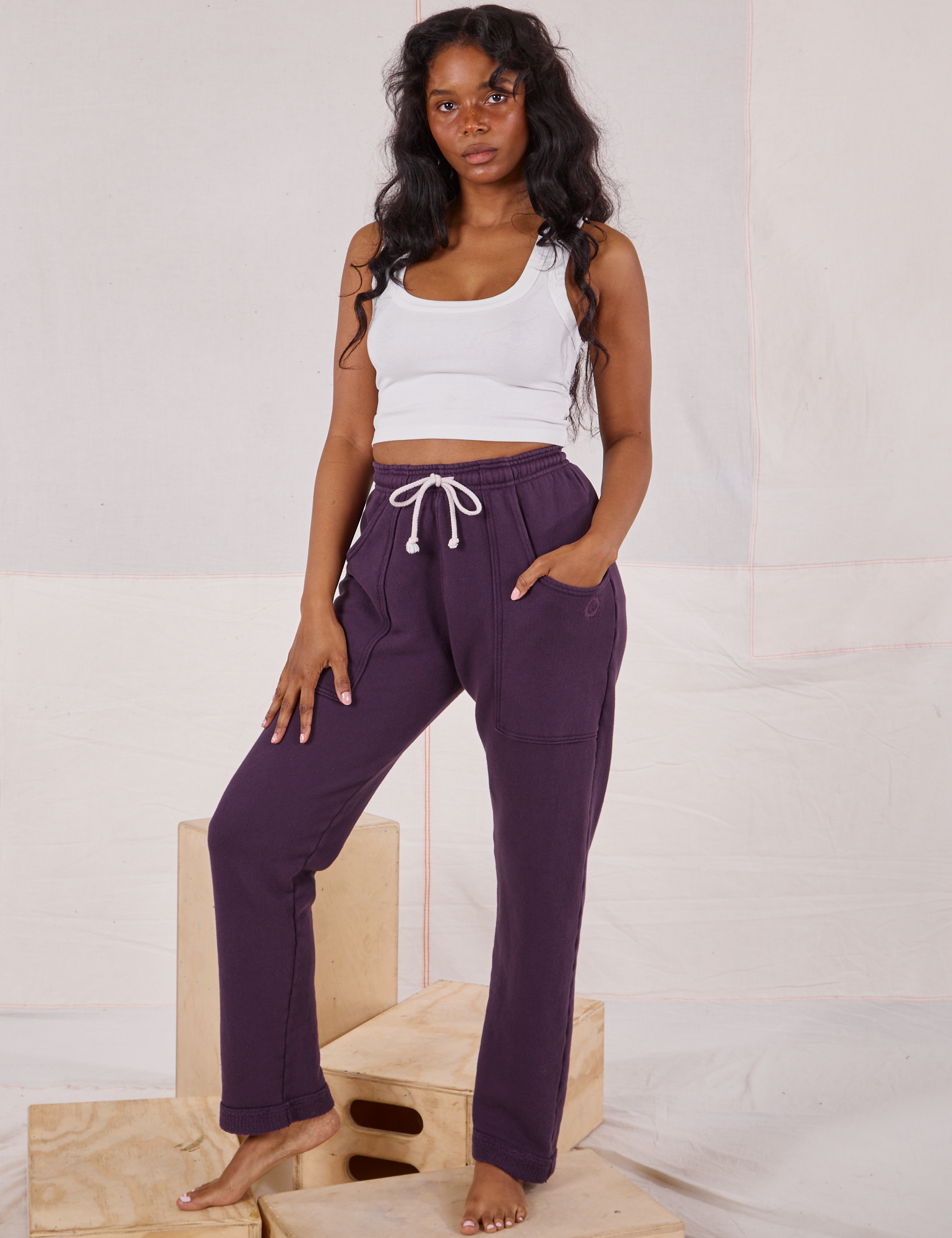 Kandia is wearing Rolled Cuff Sweat Pants in Nebula Purple and a Cropped Tank in vintage tee off-white 
