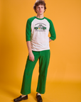 Quinn is wearing Taxi Raglan Tee in Chicago and forest green Western Pants