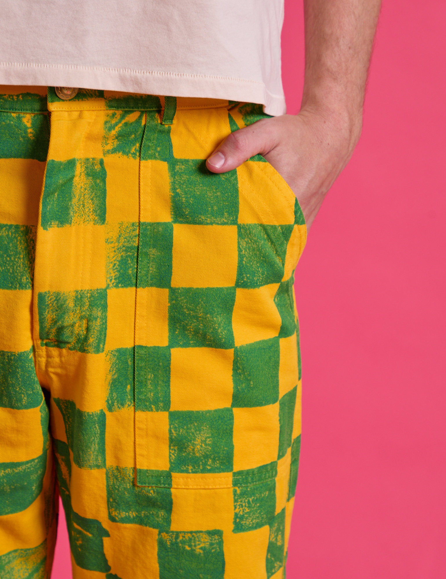 Close up of Quinn's hand in the pocket of Checkerboard Work Pants in Green/Yellow