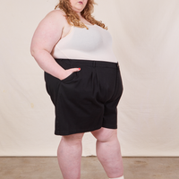 Side view of Trouser Shorts in Basic Black and vintage off-white Tank Top worn by Catie