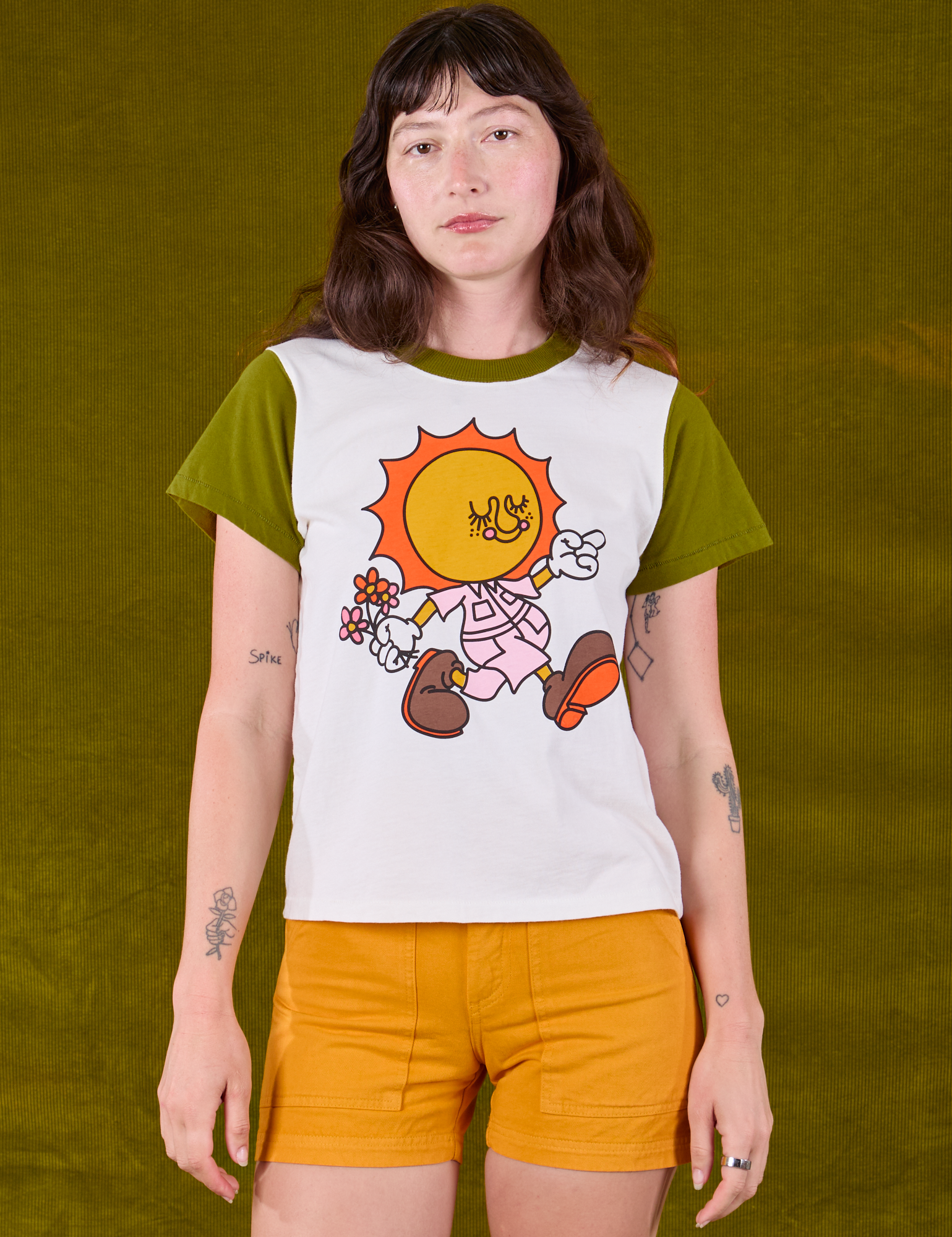 Alex is 5'8 and wearing P Anniversary Tee in Walkin' On Sun Baby paired with mustard yellow Work Shorts