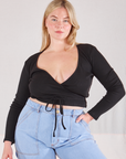 Lish is wearing Wrap Top in Basic Black and light wash Carpenter Jeans