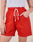 Sweat Shorts in Mustang Red front close up with Alex's hand in the pocket