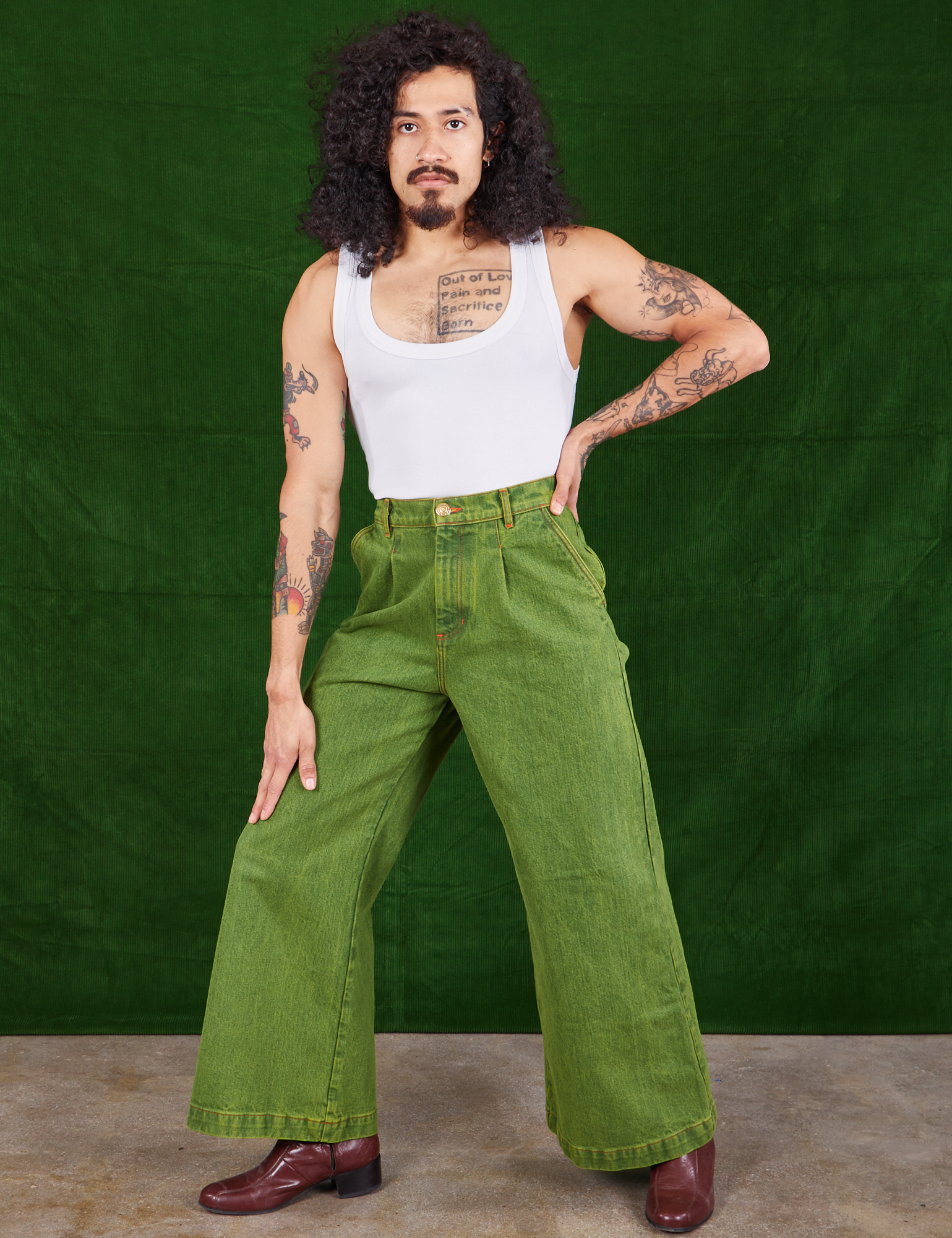 Jesse is wearing Overdyed Wide Leg Trousers in Gross Green and Cropped Tank Top in vintage tee off-white