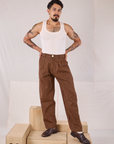 Jesse is wearing Checker Trousers in Brown & Black and a Tank Top in vintage tee off-white