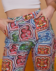Front close up of Butterfly Kaleidoscope Work Pants on Alex with her hands in the pockets