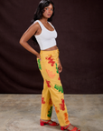 Side view of Gummy Bear Paintstamped Work Pants in Butter Yellow and Cropped Tank in Vintage Tee White