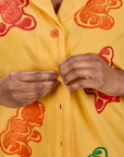 Close up of Kandia buttoning the Gummy Bear Pantry Button-Up