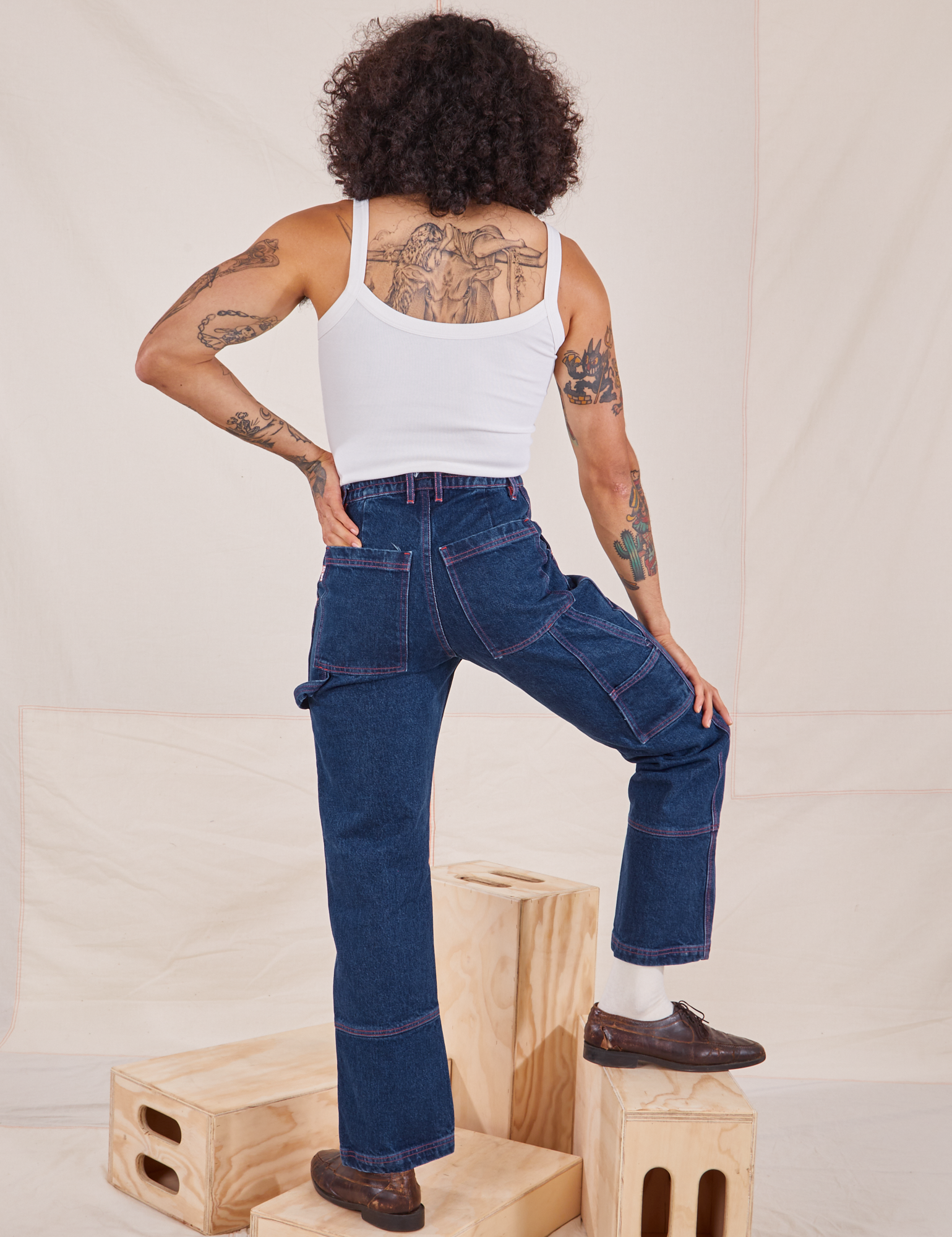 Back view of Carpenter Jeans in Dark Wash and Cropped Cami in vintage tee off-white worn by Jesse