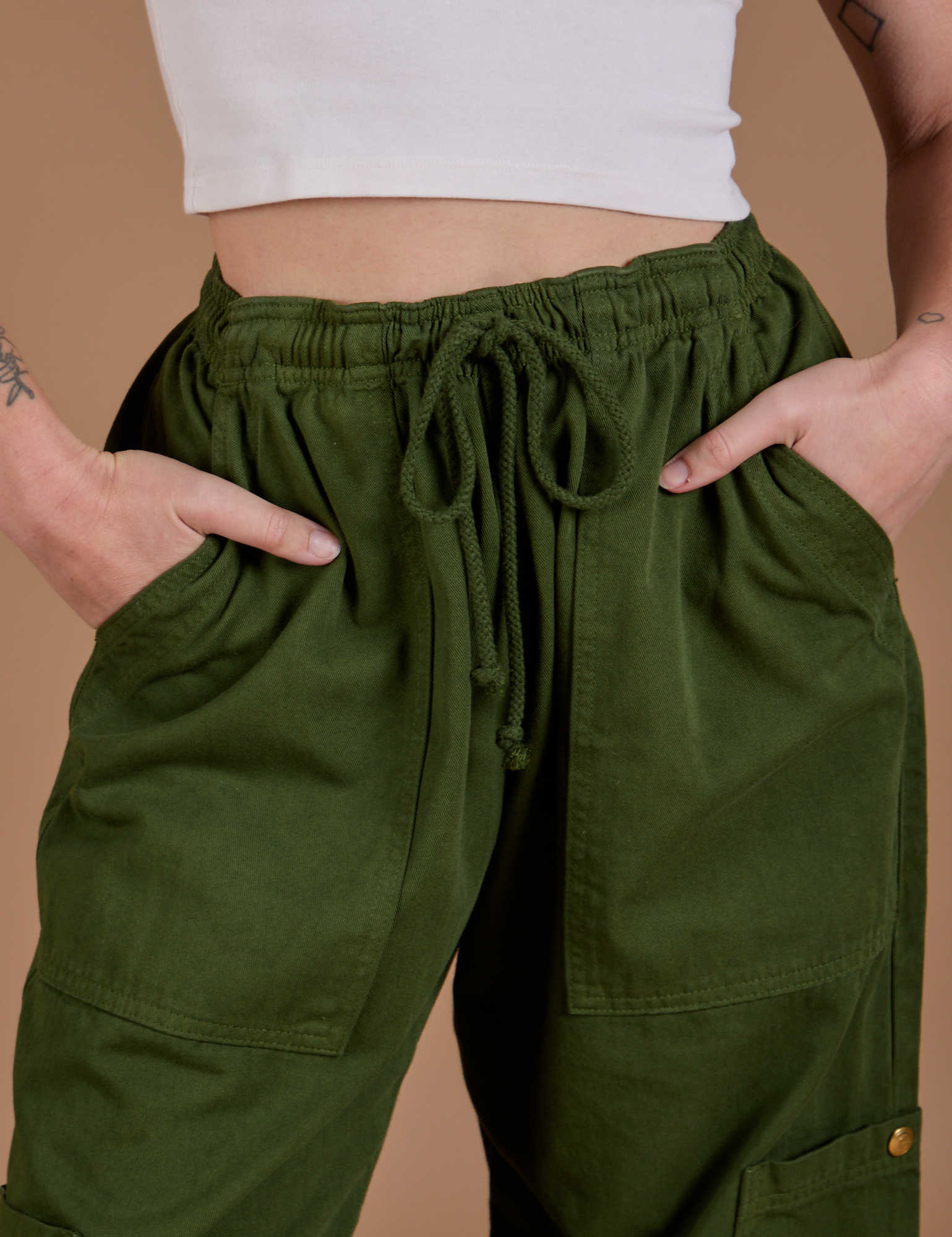 Drop Pocket Cargo Pants in Evergreen front close up with Alex's hand in both pockets