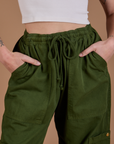 Drop Pocket Cargo Pants in Evergreen front close up with Alex's hand in both pockets
