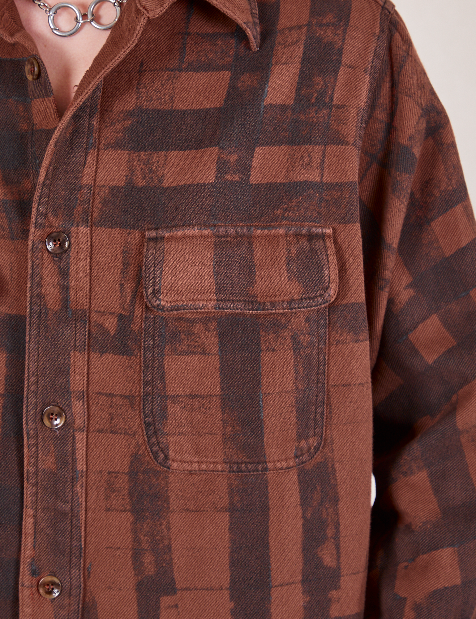 Front pocket closed up of Plaid Flannel Overshirt in Fudgesicle Brown on Alex