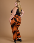 Angled back view of Black Stripe Work Pants in Construction Orange on Juliet