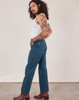 Side view of Work Pants in Lagoon and vintage tee off-white Cropped Tank on Jesse