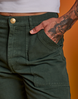 Close up of Jesse's hand in the front pocket of Paintstamped Work Pants in Cactus