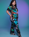 Angled front view of Short Sleeve Jumpsuit in Rainbow Magic Waters on Ashley.