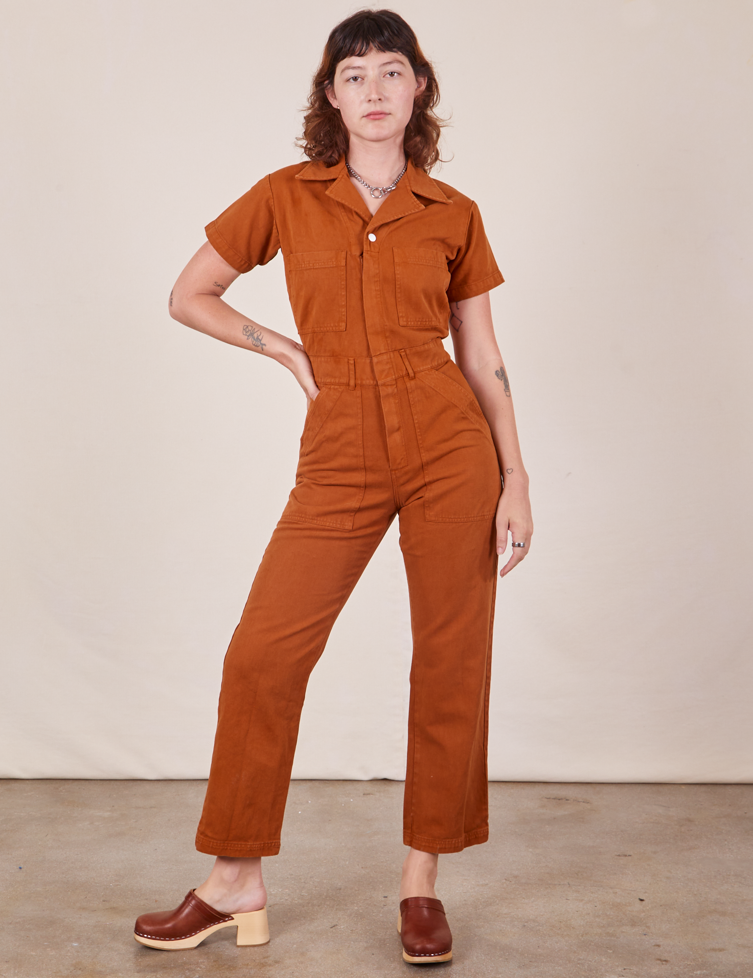 Alex is wearing Short Sleeve Jumpsuit in Burnt Terracotta