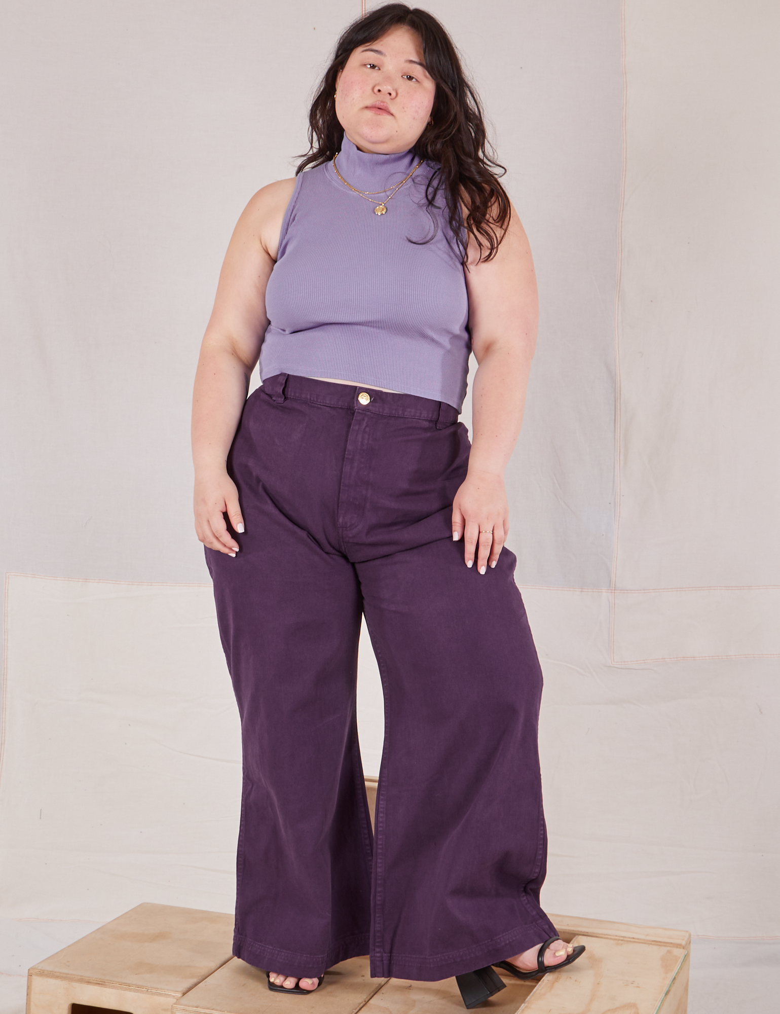 Ashley is wearing Sleeveless Essential Turtleneck in Faded Grape and nebula purple Bell Bottoms