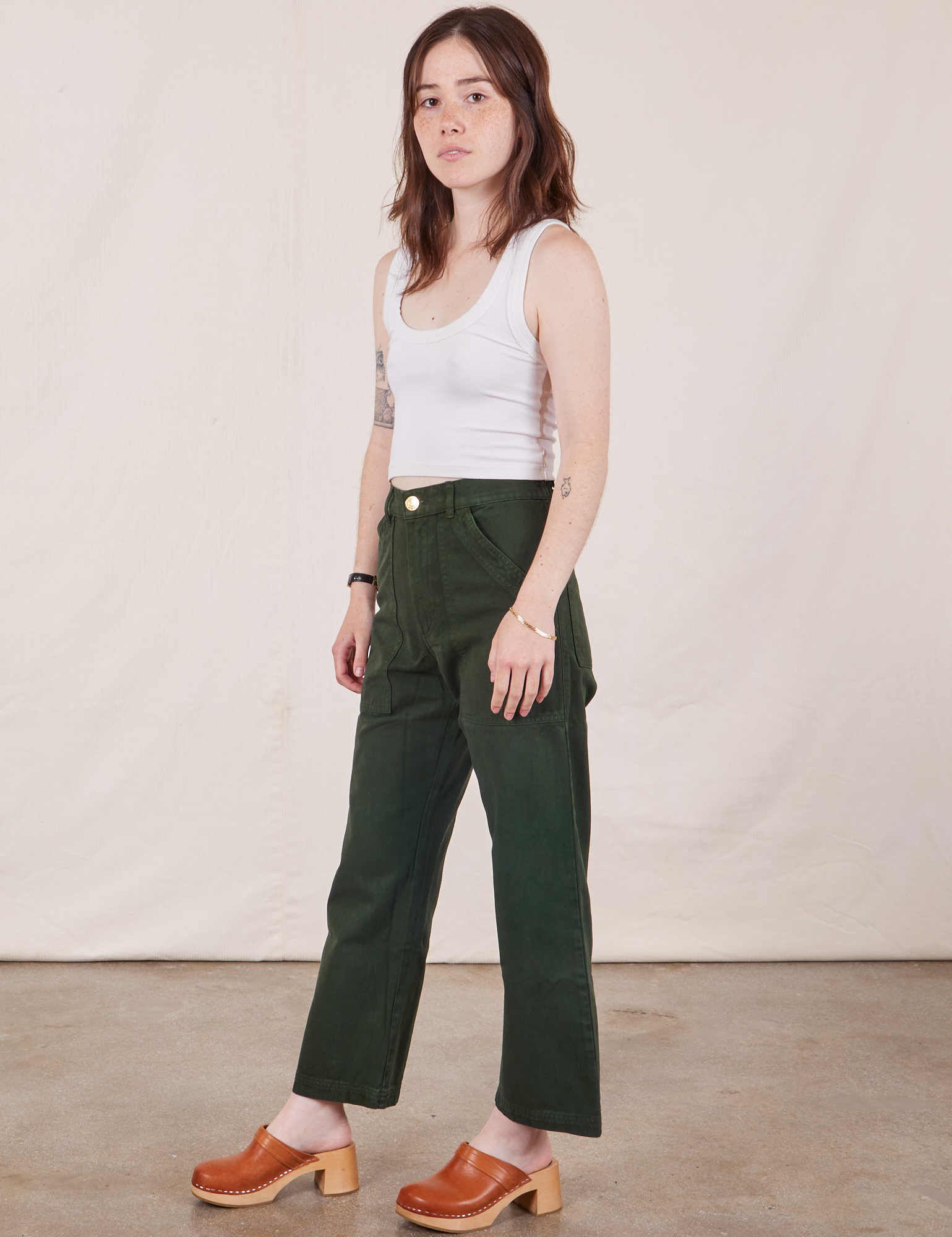 Angled view of Petite Work Pants in Swamp Green and Cropped Tank Top in vintage tee off-white on Hana