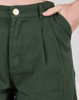 Close up of Alex's hand in the front pocket of Trouser Shorts in Swamp Green