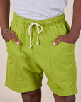 Sweat Shorts in Gross Green front close up and Isaac has both hands in the pockets