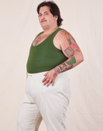 Angled view of Tank Top in Dark Emerald Green and vintage tee off-white Western Pants worn by Sam