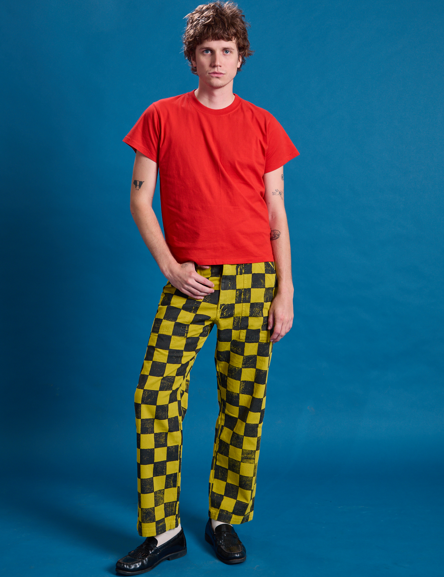 Quinn is wearing Checkerboard Work Pants in Yellow/Black and mustang red Organic Vintage Tee