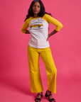 Kandia is wearing Taxi Raglan Tee in Toronto and golden yellow Western Pants