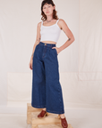 Alex is wearing Indigo Wide Leg Trousers in Dark Wash and vintage off-white Cami