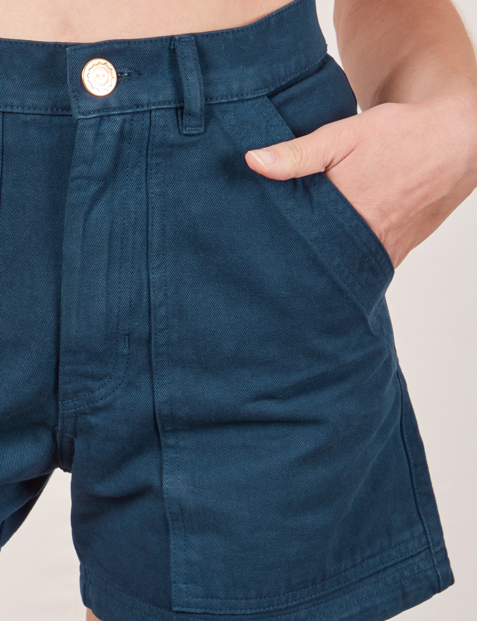 Classic Work Shorts in Lagoon front pocket close up. Madeline has her hand in the pocket.