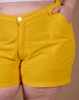 Close up of Ashley's hand in the front pocket of Classic Work Shorts in Sunshine Yellow