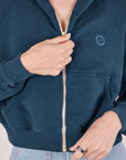 Cropped Zip Hoodie in Lagoon front close up. Alex is holding the zipper tab.