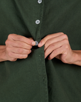 Anthony is buttoning up the Pantry Button-Up in Swamp Green