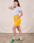 Side view of Sweat Shorts in Sunshine Yellow and stone white Jr. Varsity Tee on Alex