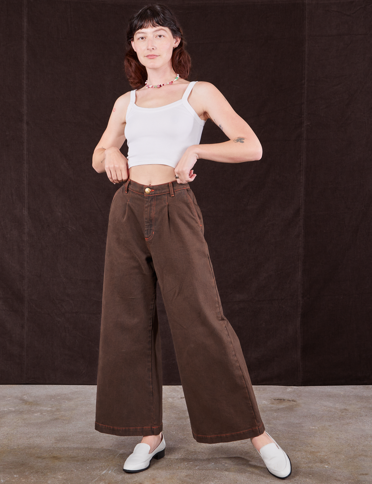 Alex is wearing Overdyed Wide Leg Trousers in Brown and Cropped Cami in vintage tee off-white