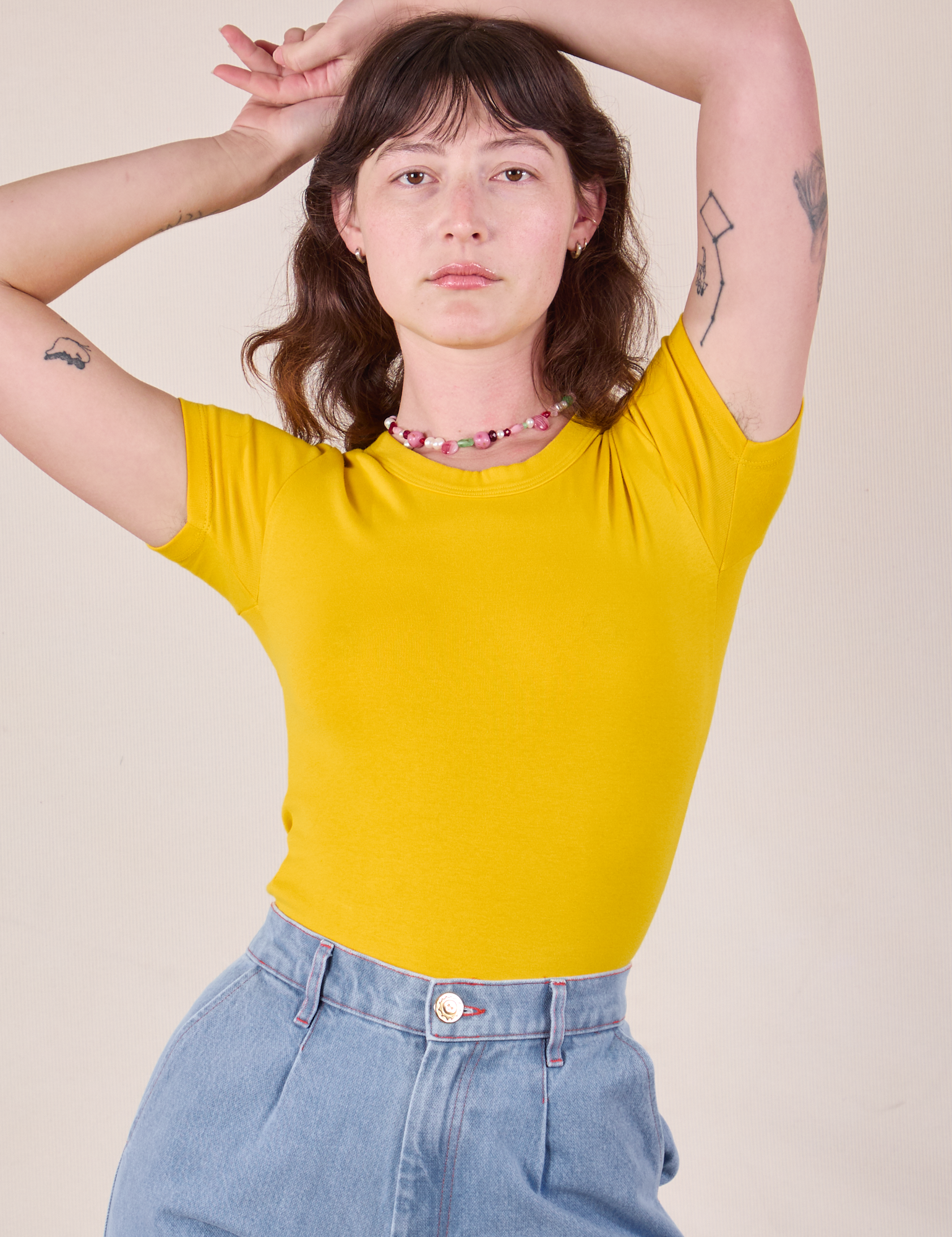 Alex is wearing Baby Tee in Golden Yellow