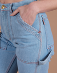 Close up of Alex's hand in the front pocket of Carpenter Jeans in Light Wash