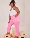 Side view of Carpenter Jeans in Bubblegum Pink and vintage off-white Tank Top worn by Morgan