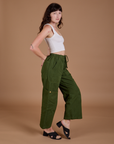 Side view of Drop Pocket Cargo Pants in Evergreen and Cropped Tank in vintage tee white on Alex