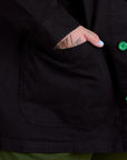 Close up of Sam's hand in the front pocket of Ripstop Field Coat in Basic Black