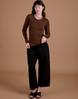 Alex is wearing Gingham Long Sleeve Baby Tee in Fudgesicle Brown and black Drop Pocket Cargo Pants