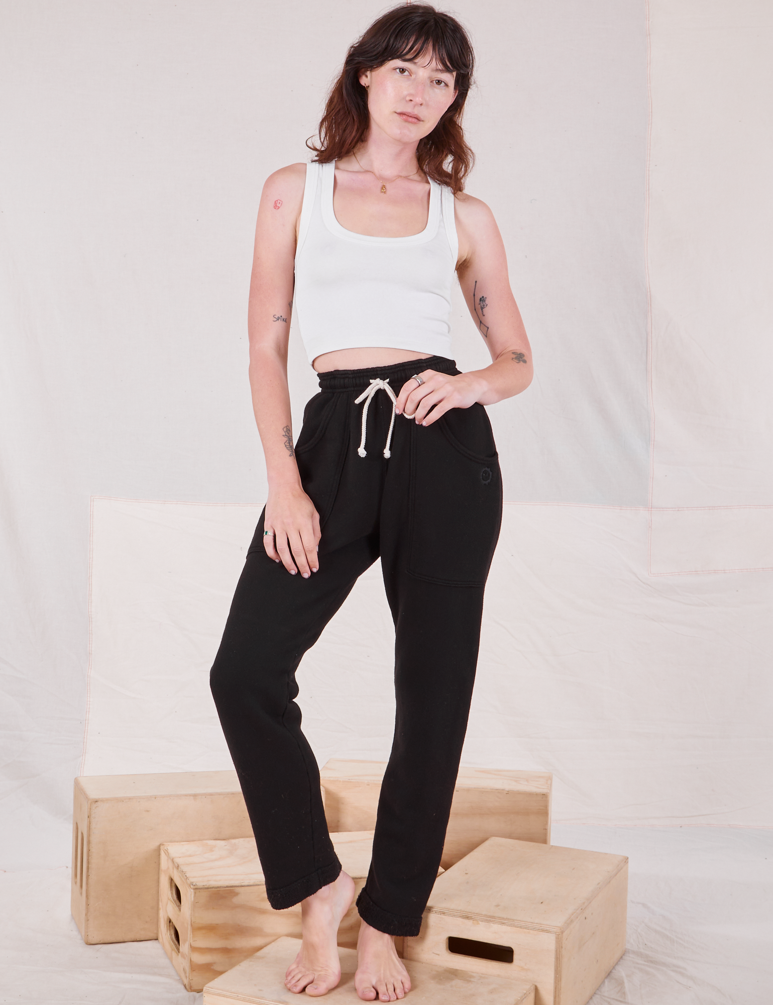 Alex is wearing Rolled Cuff Sweat Pants in Basic Black and Cropped Tank in vintage tee off-white