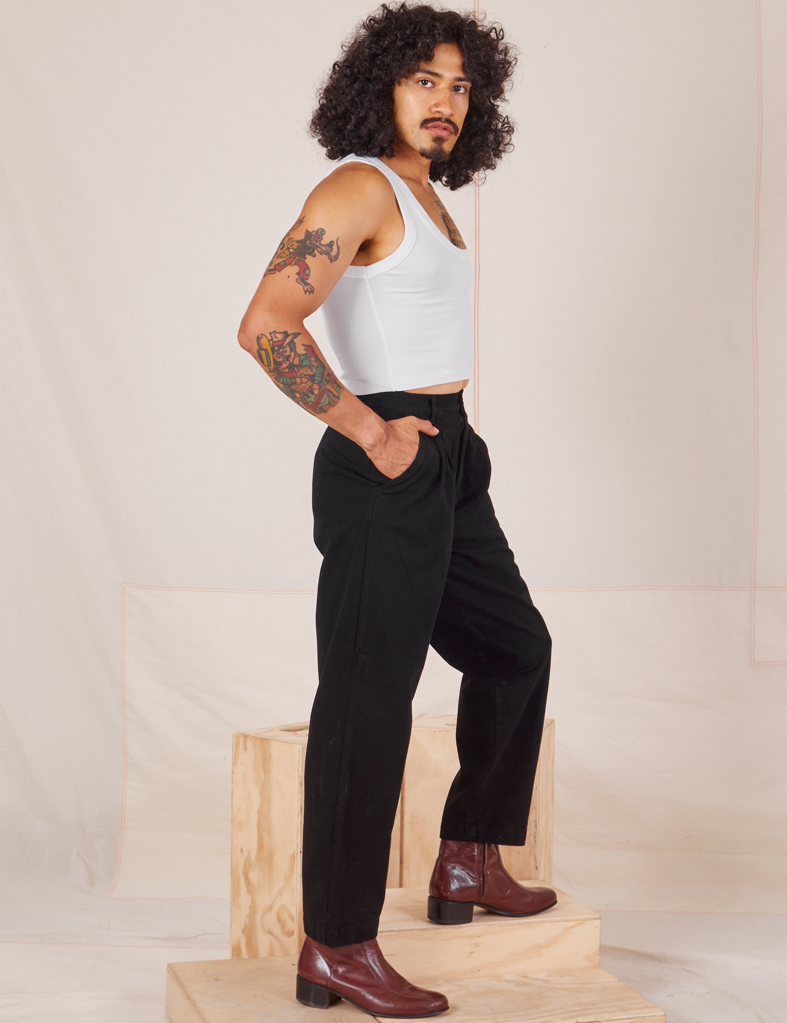 Side view of Heavyweight Trousers in Basic Black and Cropped Tank Top in vintage tee off-white worn by Jesse
