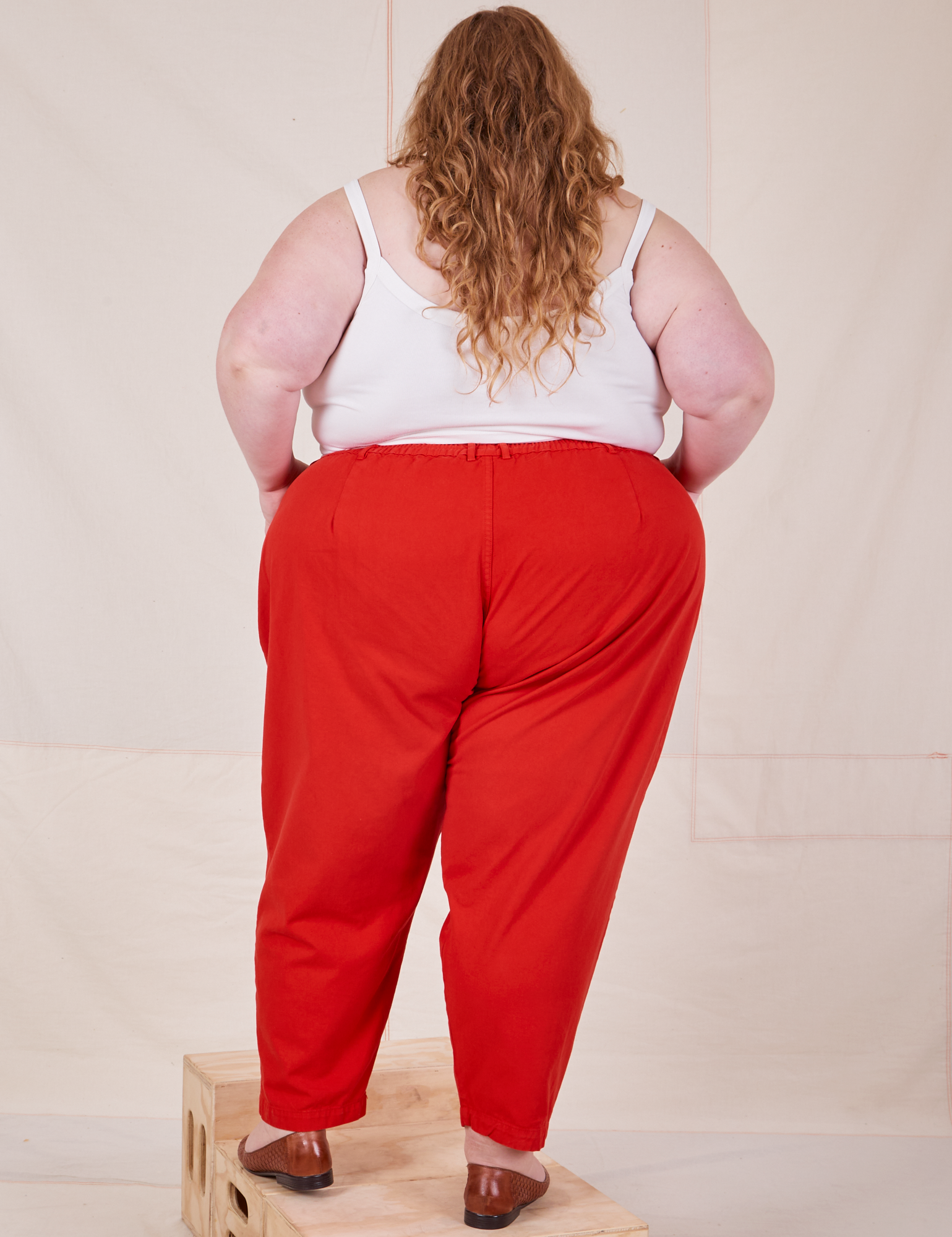 Back view of Heavyweight Trousers in Mustang Red and Cropped Cami in vintage tee off-white worn by Catie