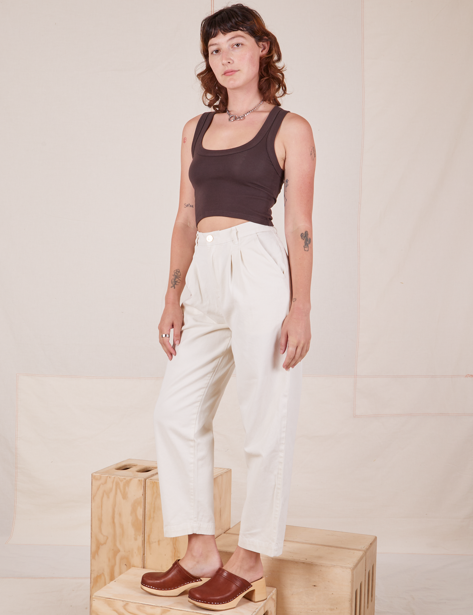 Angled view of Heavyweight Trousers in Vintage Tee Off-White and espresso brown Cropped Tank Top worn by Alex.