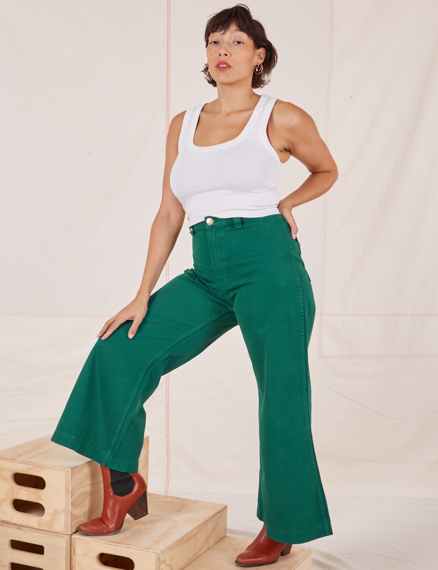Tiara is wearing Bell Bottoms in Hunter Green and Tank Top vintage tee off-white